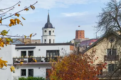 a white building with a clock tower on top of it at Apartments Satva in Vilnius