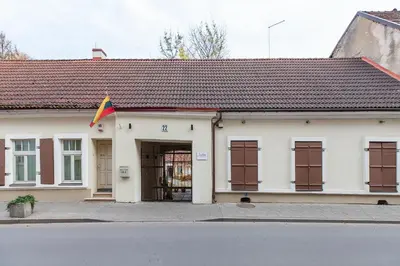 a white building with a flag in front of it at Apartments Satva in Vilnius