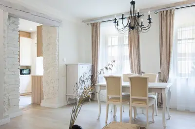 a dining room with a white table and chairs at Apartments Satva in Vilnius