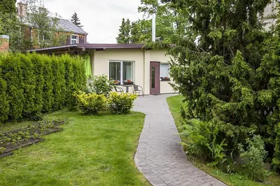 a garden with a walkway leading to a house at Agnės svečių namai in Kaunas