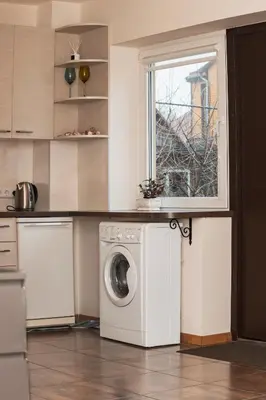 a kitchen with a washing machine and a window at Agnės svečių namai in Kaunas
