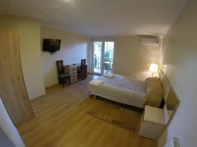 a bedroom with a bed and a desk and a television at Kambarių nuoma Kačerginės kurorte in Kačerginė