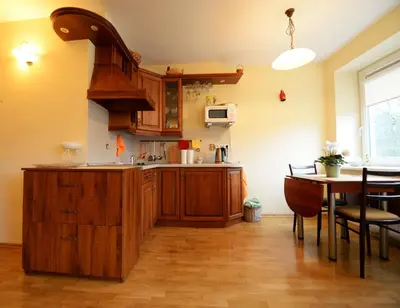 a kitchen with wooden cabinets and a table in a room at Ramresort Apartment in Birštonas