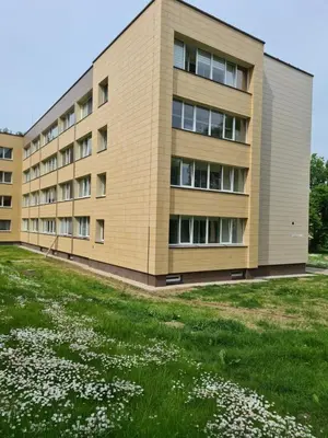an apartment building with a field of flowers in front of it at Ramresort Apartment in Birštonas