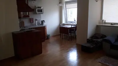 a living room with a kitchen and a table at Ramresort Apartment in Birštonas