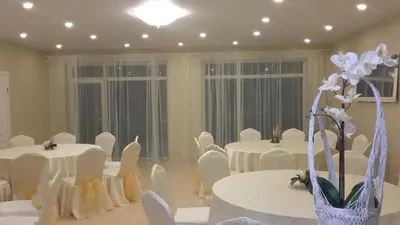 a room with white tables and white chairs and flowers at MS Resort in Nemėžis