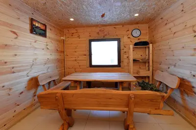 a wooden dining room with a table and a window at MS Resort in Nemėžis