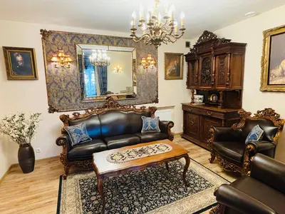 a living room with a leather couch and a table at Grand Duke Apartments in Vilnius