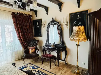 a bedroom with a mirror and a chair and a lamp at Grand Duke Apartments in Vilnius