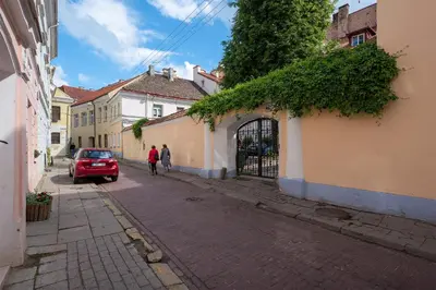 two people walking down a street with a red car at Grand Duke Apartments in Vilnius