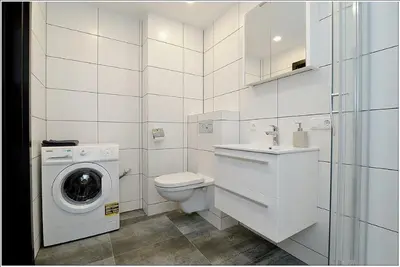 a white bathroom with a washing machine and a washer at New Studio In Oslo Namai in Vilnius