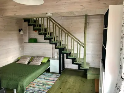 a room with a green bed and stairs at Guest House Mr Fox in Druskininkai