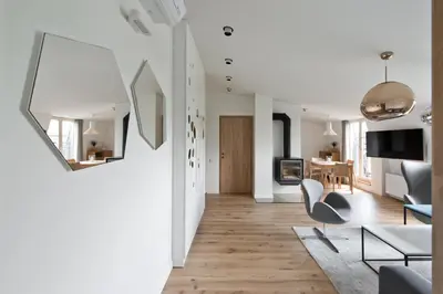a living room with white walls and wooden floors at Aura apartamentai in Druskininkai