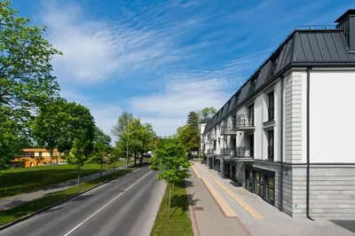 an empty street next to a white building at Aura apartamentai in Druskininkai