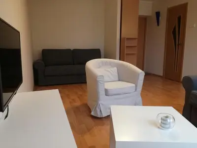 a living room with a white chair and a couch at Apartment for rent Druskininkai in Druskininkai