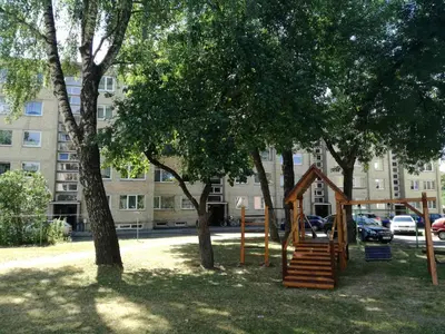 a playground in a park in front of a building at Apartment for rent Druskininkai in Druskininkai