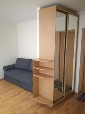 a living room with a blue couch and a mirror at Apartment for rent Druskininkai in Druskininkai
