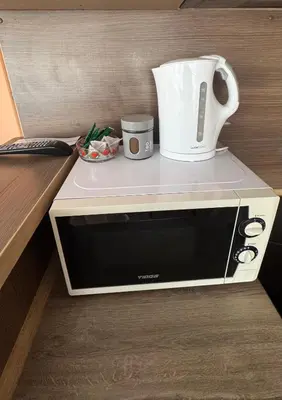 a microwave with a jug on top of it at Apartamentai KAVA in Zarasai