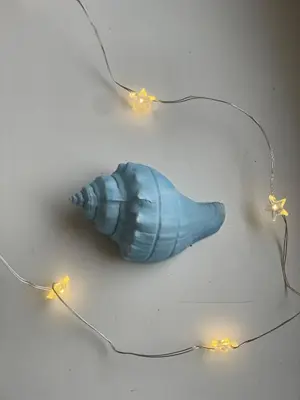 a blue shell with lights on a table at Apartamentai KAVA in Zarasai