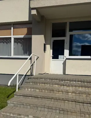 a house with stairs leading to a door at Apartamentai KAVA in Zarasai