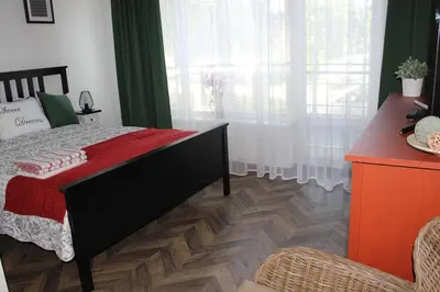 a bedroom with a bed with a red blanket on it at Luxury Apartment in Druskininkai