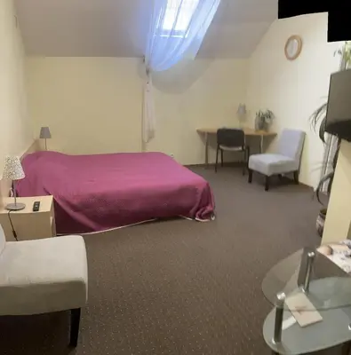 a bedroom with a purple bed and a table and chairs at Valentina's Rooms in Vilnius