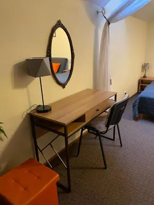 a room with a desk with a mirror and a bed at Valentina's Rooms in Vilnius