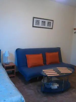 a living room with a blue couch and a table at Valentina's Rooms in Vilnius