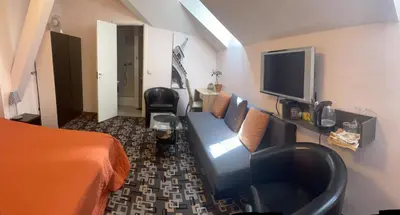 a hotel room with a blue couch and a tv at Valentina's Rooms in Vilnius