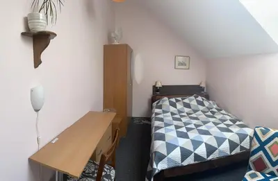 a small bedroom with a bed and a desk at Valentina's Rooms in Vilnius