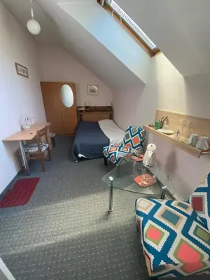 a small room with a bed and a table at Valentina's Rooms in Vilnius