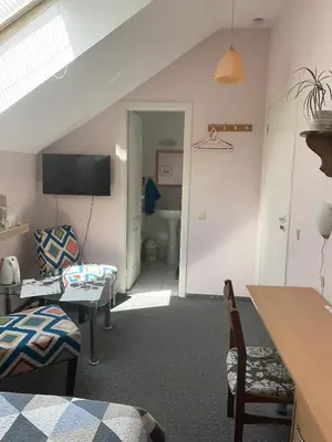 a room with a bed and a living room with a couch at Valentina's Rooms in Vilnius
