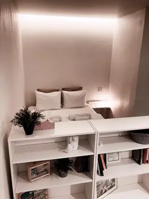 a white room with a bed and a mirror at Marijampole Apartment with FREE Parking in Marijampolė
