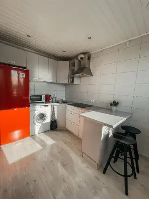 a kitchen with an orange refrigerator and a counter at Marijampole Apartment with FREE Parking in Marijampolė
