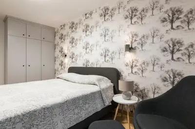 a bedroom with a bed and a couch and a wall mural at SoulHouse apartments in Druskininkai