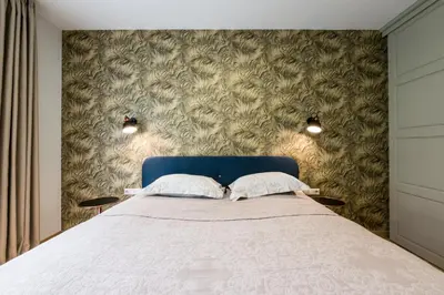 a bedroom with a bed with a blue headboard at SoulHouse apartments in Druskininkai