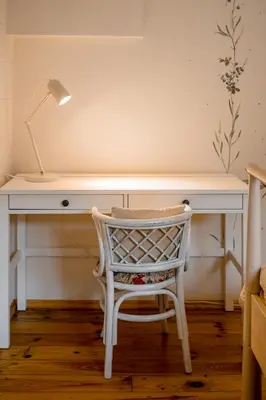 a white desk with a chair and a lamp at Villa Kurorto Namas in Druskininkai