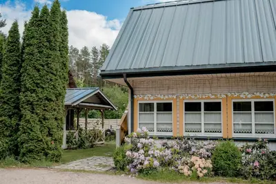 a house with flowers in front of it at Villa Kurorto Namas in Druskininkai