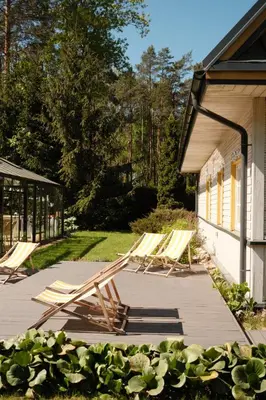 a group of lawn chairs sitting on a deck at Villa Kurorto Namas in Druskininkai