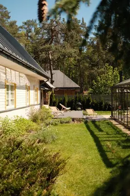 a yard with a house and a yard sidx sidx sidx at Villa Kurorto Namas in Druskininkai