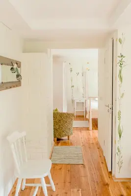 a white room with a white chair and a table at Villa Kurorto Namas in Druskininkai