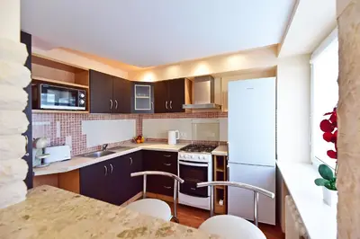 a kitchen with brown cabinets and white appliances at Oksanos apartamentai Druskininkuose atskiras įėjimas 1 aukštas in Druskininkai