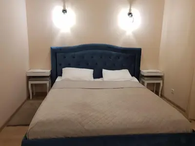 a bedroom with a blue bed with two night stands at Oksanos apartamentai Druskininkuose atskiras įėjimas 1 aukštas in Druskininkai