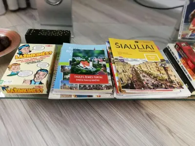 a pile of books sitting on top of a table at Draugystės Apartment in Šiauliai
