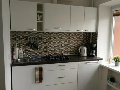 a kitchen with white cabinets and a sink at Draugystės Apartment in Šiauliai