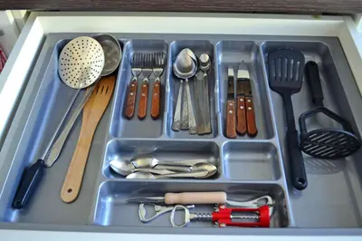 a tray filled with utensils in a drawer at Draugystės Apartment in Šiauliai