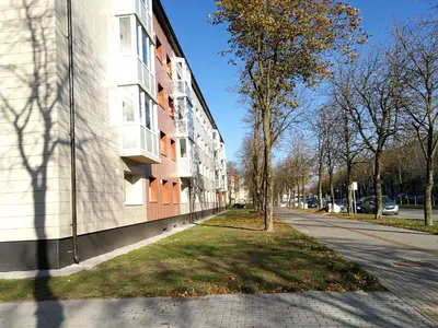 an empty street next to a white building at Draugystės Apartment in Šiauliai
