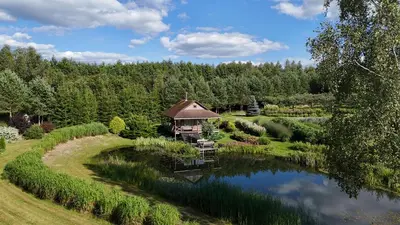 a house in the middle of a pond in a garden at Mikalojiškis in Inturkė