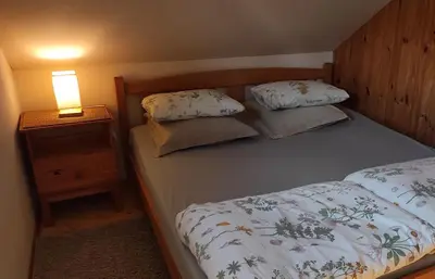 a bedroom with a bed and a night stand with a lamp at Mikalojiškis in Inturkė