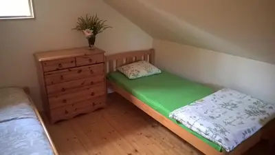 a small bedroom with a bed and a dresser at Mikalojiškis in Inturkė